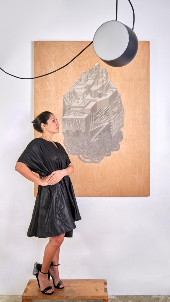 Art collector Dr. Joanna Delia in front of a painting by Teresa Sciberras. Photo by Matt Thompson