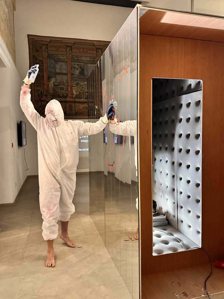 The artist Gabriel D. Doucet Donida performing alongside his installation "The Confessional / Infinite Habitat" at Deep Throat, an exhibition organised by MOMENTUM. [The Confessional will be exhibited at GROUND 99 - a satellite event at The Malta Biennale 2026 curated by Rachel Rits-Volloch, 12 March - 16 May 2026]